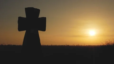 Big stone cross in a field at sunset in the rays of the sun Stock Footage 103568562