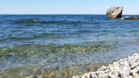 A big stone on the shore of the lake. Vídeo Stock 292512412