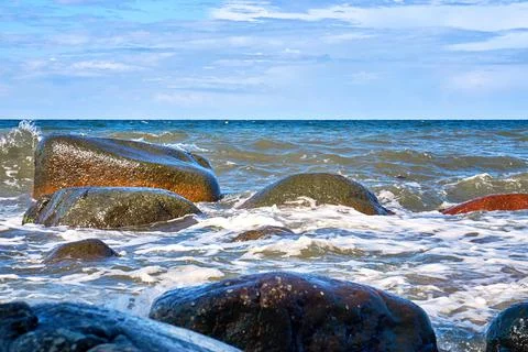 Big stones in the Baltic Sea with foaming waves on the shore. Stock Photos