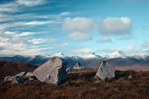 Big stones in the foreground and snowy mountain peaks Stock Photos