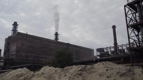 A big stovepipe smokes on the mining and processing plant Stock Footage 95148019