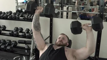 Big strong guy training with dumbbells close-up 4k. Stock Footage 85591001