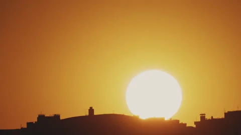 Big sun and a view of the rooftops of the city. Timelapse Stock Footage 316536248
