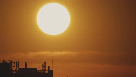 Big sun and a view of the rooftops of the city. Timelapse Stock Footage 316537042