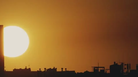 Big sun and a view of the rooftops of the city. Timelapse Stock Footage 316537375
