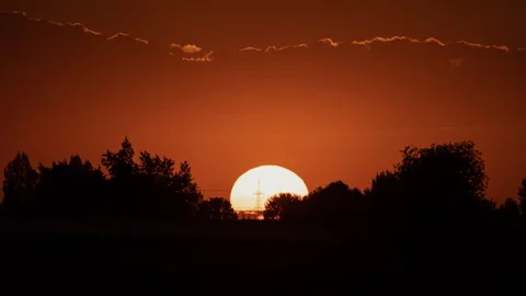 Big sun, sunset landscape behind treetops and energy masts, magnificent sunset Vidéo 251800874