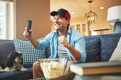 Big support for the big game. a happy man celebrating while watching a sports Stock Photos