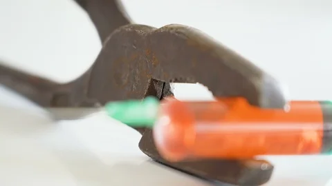 A big syringe on the jaw of the rusty pliers Stock Footage 129454925