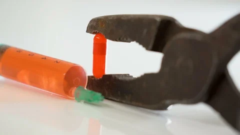 A big syringe on the side of the rusty pliers Stock Footage 129453807