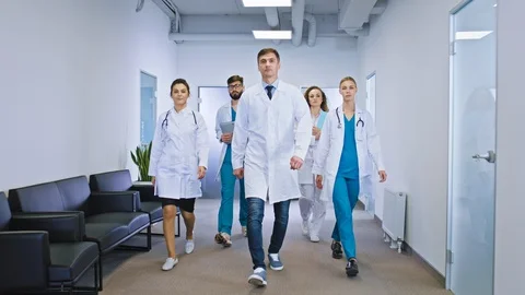 Big team of doctors and nurses multiethnic in the hospital corridor walking in Stock Footage 129397021