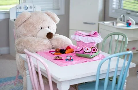 A big teddy bear has a colorful picnic in the play room Stock Photos