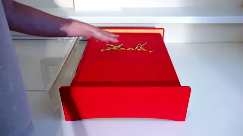 Big thick book covered with a red cloth with an engraving on the front of Stock Footage 68085173