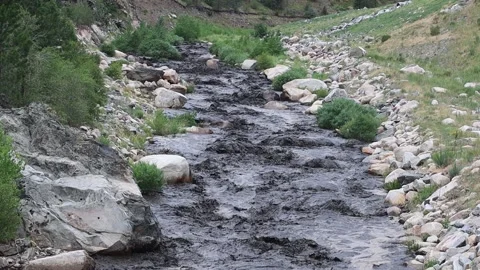 Big Thompson river blackened by ash and mud following a mud slide in a Stock Footage 201404220