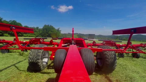 Big tractor is pulling a huge machine with rotary rakes behind it Stock Footage 66865147