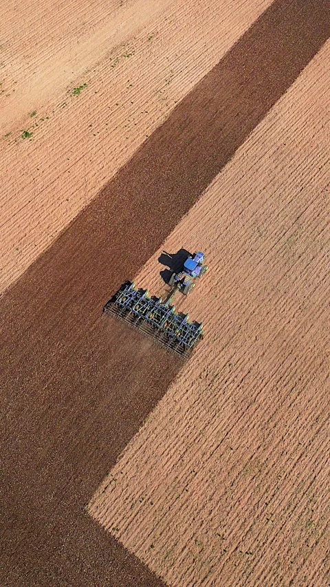 Big tractor tills vast field, aerial view Stock Footage 310259156