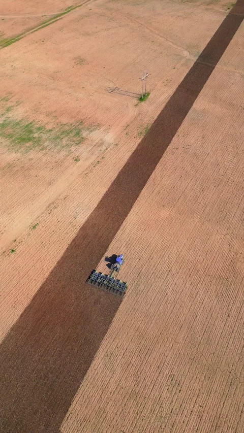 Big tractor tills vast field, aerial view Stock Footage 310259168
