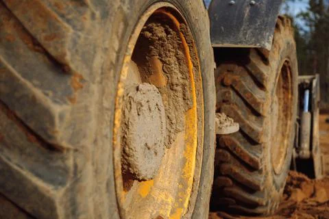 Big tractor wheels at a construction site standing in the sand Stock Photos