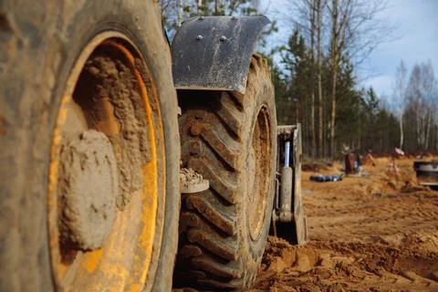 Big tractor wheels at a construction site standing in the sand Stock Photos