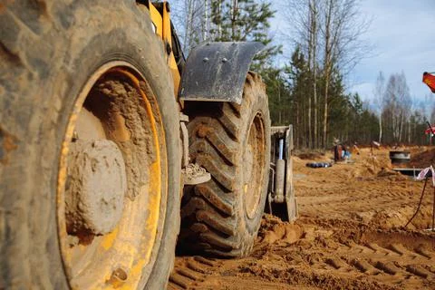 Big tractor wheels at a construction site standing in the sand Stock Photos