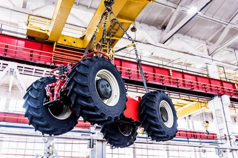 Big tractor wheels installation at assembly room at industrial plant Foto stock