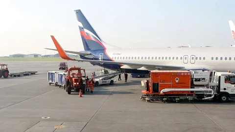 Big traffic of passengers airliners and service cars ride at airdrome Stock Footage