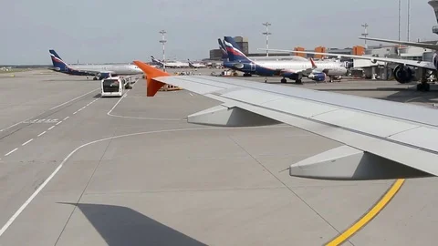 Big traffic of passengers airliners and service cars ride at airdrome Stock Footage 80647178