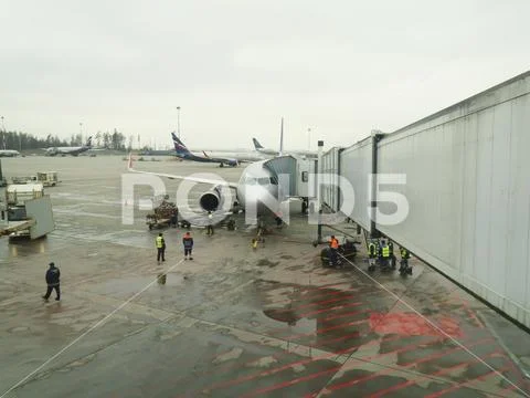 Big traffic of passengers airliners and service cars ride at airdrome Stock Photos