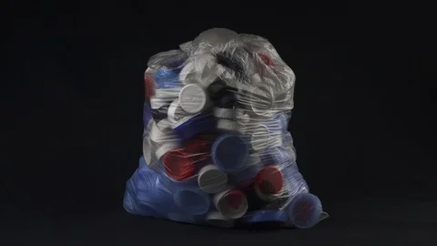 Big transparent bag filled with plastic bottle caps for recycling Stock Footage 124644673