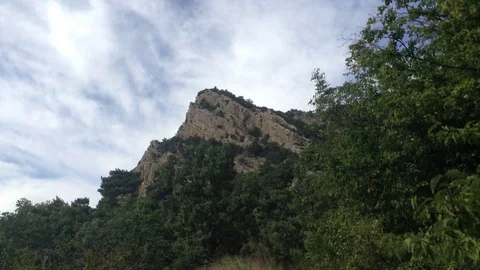 Big triangle mountain and forest trees &amp; white clouds at cape Aya Crimea Russia Stock Footage 119307923