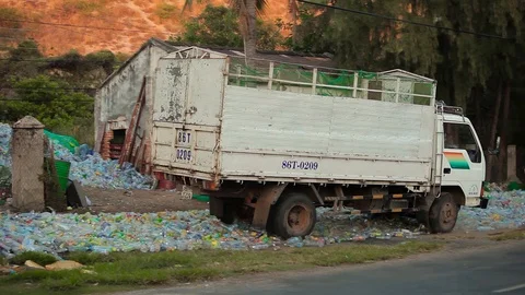 Big truck goes back and forth to make plastic bottle flat in Vietnam in spring Stock Footage 100799093