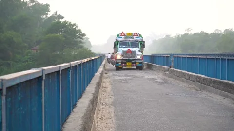 Big trucks passing through a blue iron bridge 動画素材 217532722