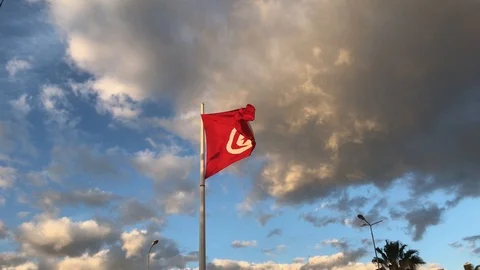 Big tunisian flag flaping in the wind, blue sky and clouds in background Stock Footage 105607955