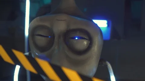 A big UFO head hangs upside down. Eyes shimmer in blue. Located behind the warni 스톡 동영상 98865801