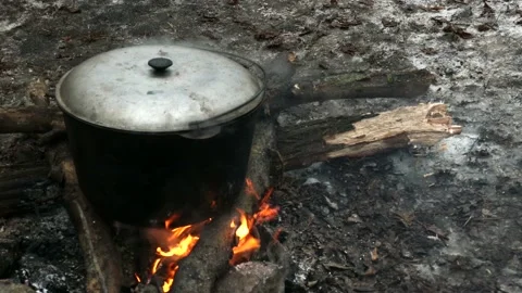 Large cauldron with a lid on a fire. Big vat with food cooking on