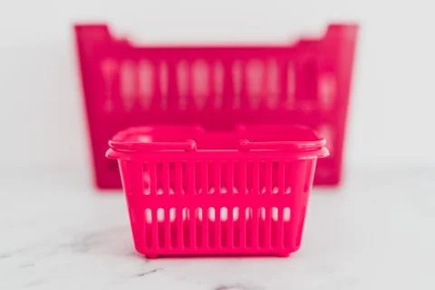 Big vs small budget concept with different size shopping baskets next to each Stock Photos