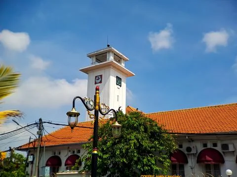 Big wall clock in an old white building in Madiun, East Java, Indonesia, with 库存照片