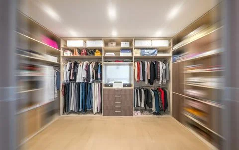 Big wardrobe with different clothes for dressing room with motion blur effect Stock Photos