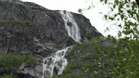 Big waterfall cascade dropping of a steep cliff in Norway Stock Footage 235153904
