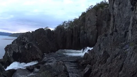 Big waterfall in the cliff, top view. White night, Finnmark, Norway. Summer 2016 Stock Footage 69176343