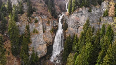 Big waterfall in the mountains. Flying between trees over green mountain forest Stock Footage 150664566