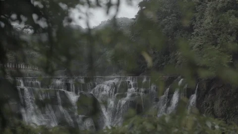 Big waterfall seen through leaves Stock Footage 87787605