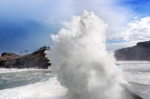 Big wave breaking on breakwater Stock Photos