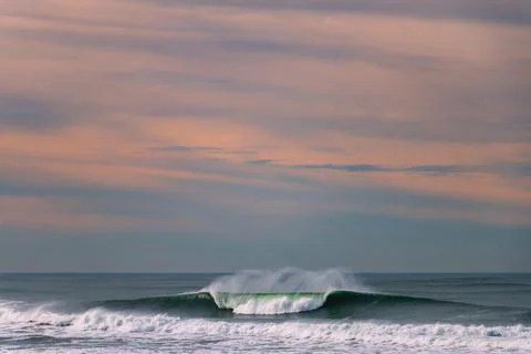 A big wave breaks in the Pacific Ocean on a California beach Stock Photos