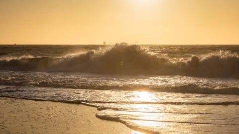 Big wave from hard wind touching big rock of Baker Beach at sunset Stock Photos