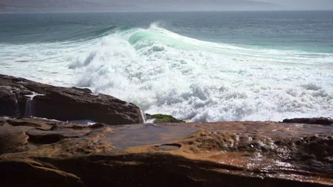 A big wave hit beachrocks hard and make big splashes in slow motion Stock Footage 296688938