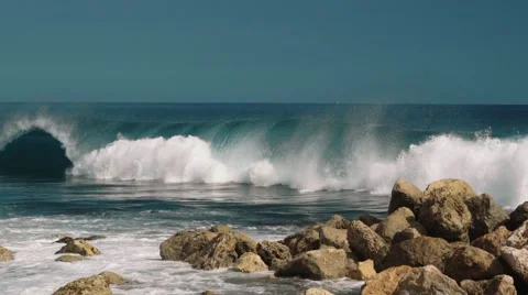 Big wave hitting rocks, clear blue sky Stock Footage 63529134