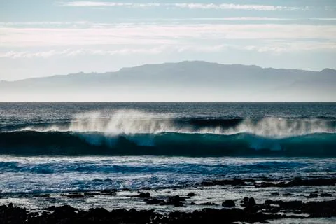 Big wave rolling it and crush at the beach with another tropical island in th Foto stock