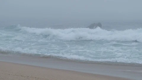 Big wave in slow motion, breaking on beach with very dense fog in autumn. Stock Footage 116183176