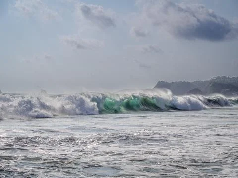 Big waves against the background of forested hills Stock Photos