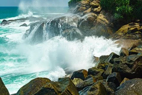 Big waves and lots of splashes with foam on the rocky shore Stock Photos